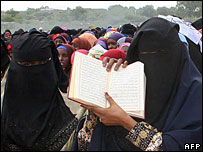 Women in veils holding the Koran